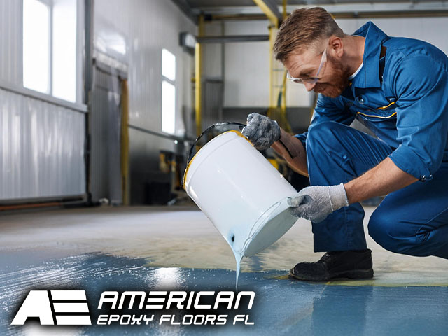 male professional technician performing professional installation pouring automotive epoxy solutions onto floor in garage